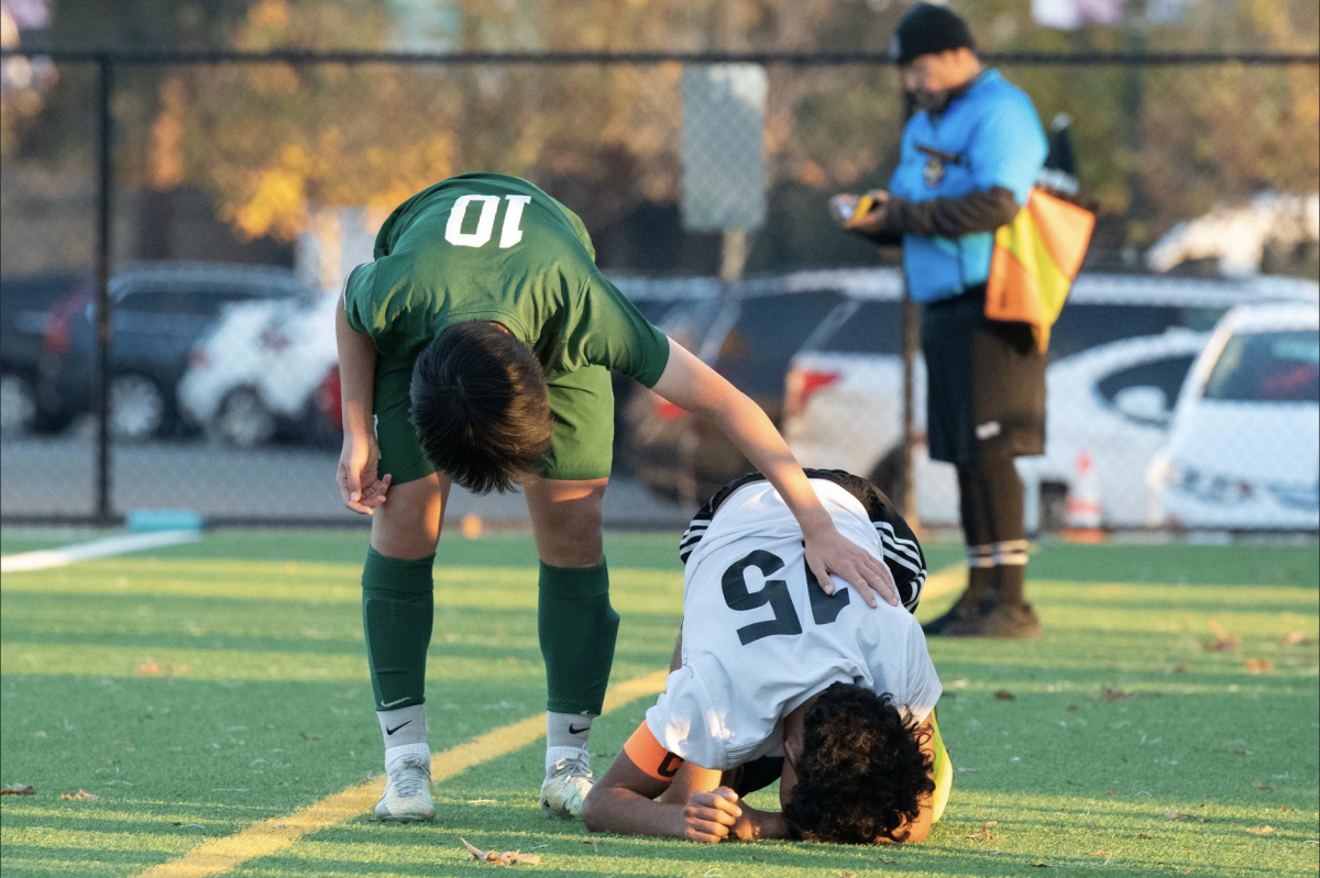 Varsity boys soccer co-captain Jack Yang (12) checks on a potentially injured player from the opposing team in a show of sportsmanship. Jack has played on the varsity team since his freshman year, becoming captain in his junior season. 