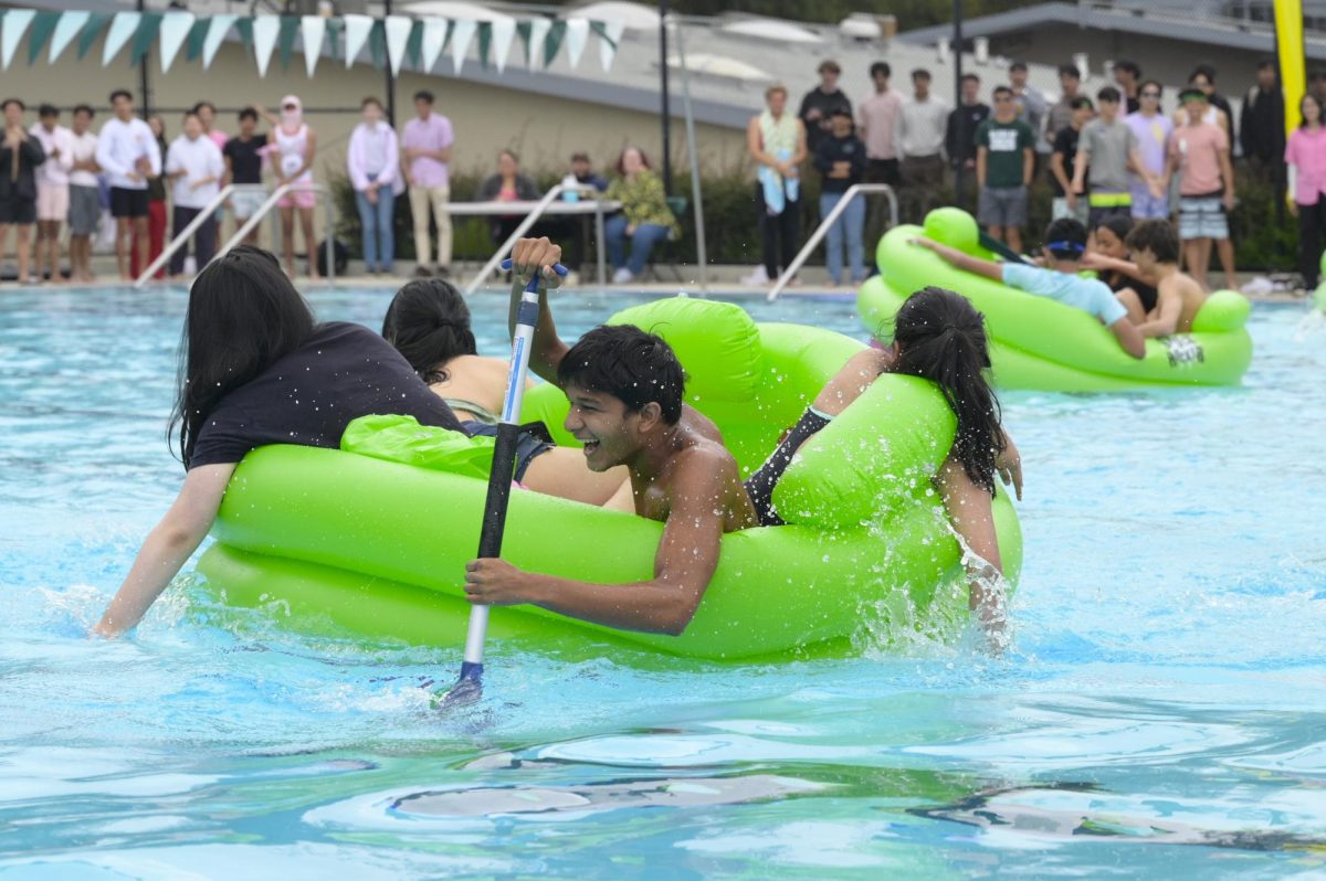 Senior Saahil Kajarekar paddles the class of 2024s regatta floatie across the pool. “I think its cool because a lot of the students put all their time into the spirit stuff,” belly flop judge Kadar Arbuckle said. “I actually really like how they make it more official with the judges. I was just here today to add to that.”