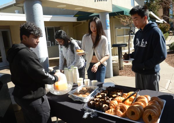 Ritu Belani (12), Anna Lee (12) and Caden Ruan (10) choose food options from the LIFE Boards snack bar after school on March 14. The board set up the snacks as a healthier alternative option with orange juice, donuts and more.
