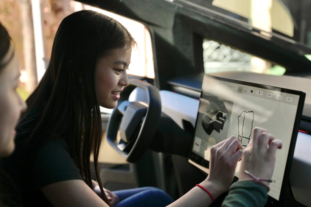BEcon attendee Mindy Truong (10) explores the inside of a Tesla Cybertruck. Companies like Tesla and Apple hosted interactive booths at 3:30 pm.
