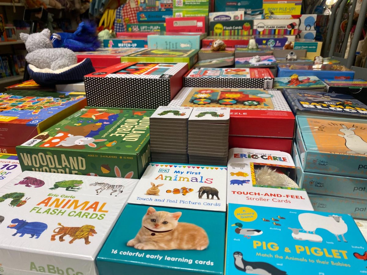 A table at Posman Books displays a selection of kids books and board games. Customers can also browse through a selection of stuffed animals, candles, mugs and more.