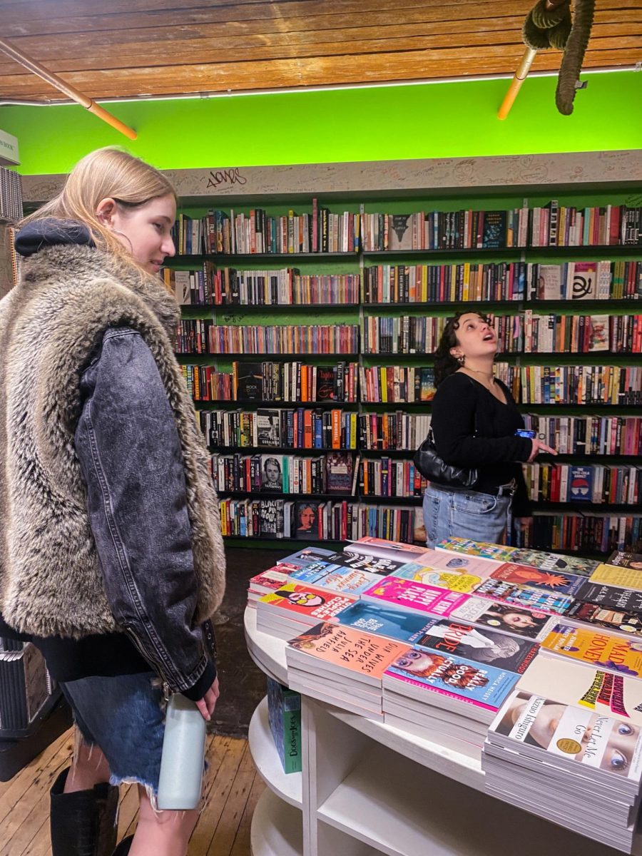 Two customers admire the selection around them at Posman Books. “Everyones able to find something that they love, whether theyre one year old or 90 years old,” Alex said. “Theres something for everyone.