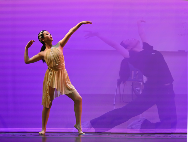 Dancer Selina Wang (10) performs in the upper school dance production, with an image of her rehearsing in the background. Despite the intense training required of dancers, many forms of dance strive to hide strain on stage. 