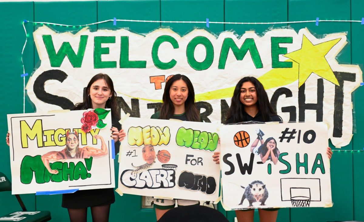 Seniors Masha Velikhovskaya, Claire Miao and Isha Kotalwar hold their posters for a photo. The seniors were gifted flowers and posters from their teammates and families.