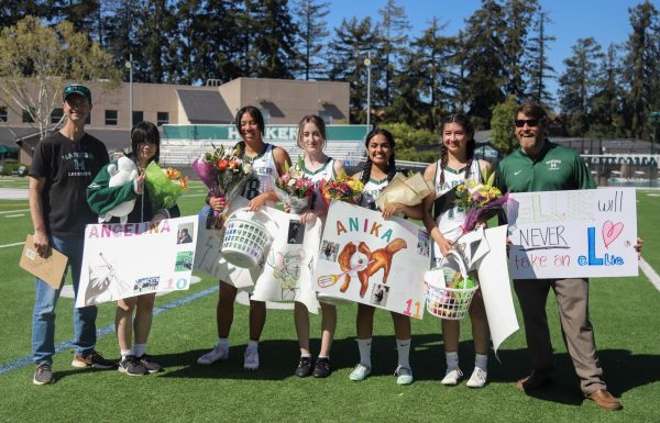 Seniors Angelina Hu, Olivia Xu, Katherine Fields, Anika Mantripragada and Ellie Schmidt line up with assistant coaches Doug Hawk and Andrew Irvine for a picture during the team’s senior night ceremony. Irvine gave a speech for each senior, honoring their time with the team. 