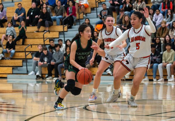 Isabella Lo (11) drives downhill, looking for an open teammate in the Harker varsity girls basketballs Central Coast Section semifinal game. Isabella often handled the ball at the point guard position.