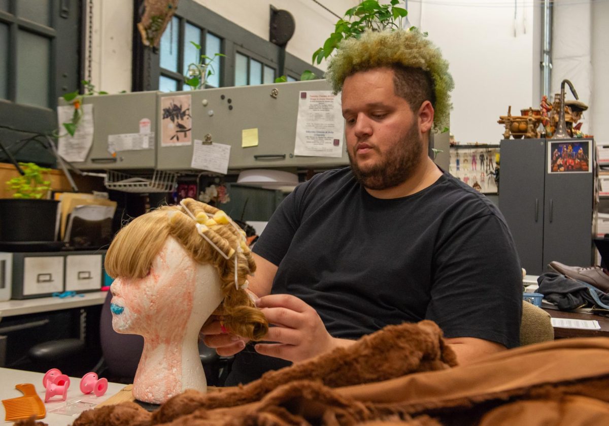 Zachary Hampton fashions a wig that an actor playing Goldilocks will wear for the theatres dress rehearsal. Zachary is playing the Papa Bear role for the companys upcoming show.