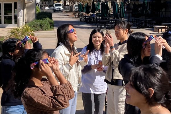 Students and staff witness the partial solar eclipse with special solar viewers. These glasses prevent eye damage by filtering out harmful radiation from the Sun.