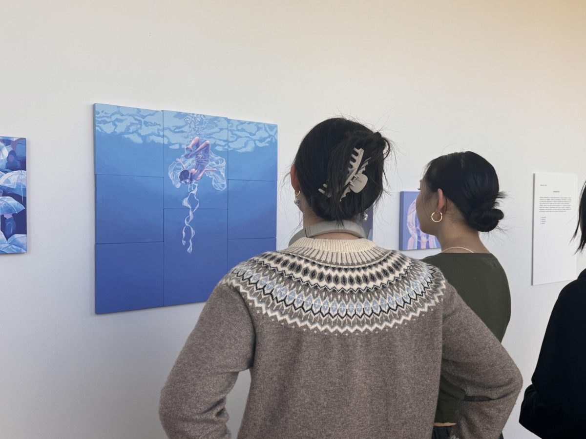 Julie Shi (12) and Sonia Yu (11) view Claires painting titled Deep End. Claire held her portfolios reception on Feb. 22 along with Angelina and Maryam. 