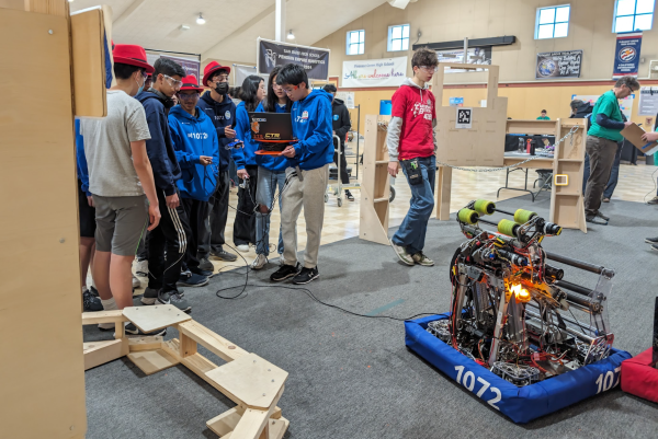 Team 1072s technical president Chiling Han (11) runs code on the robot at the competitions practice field. Despite multiple rounds of bug fixes, the robots autonomous routine failed to run properly.