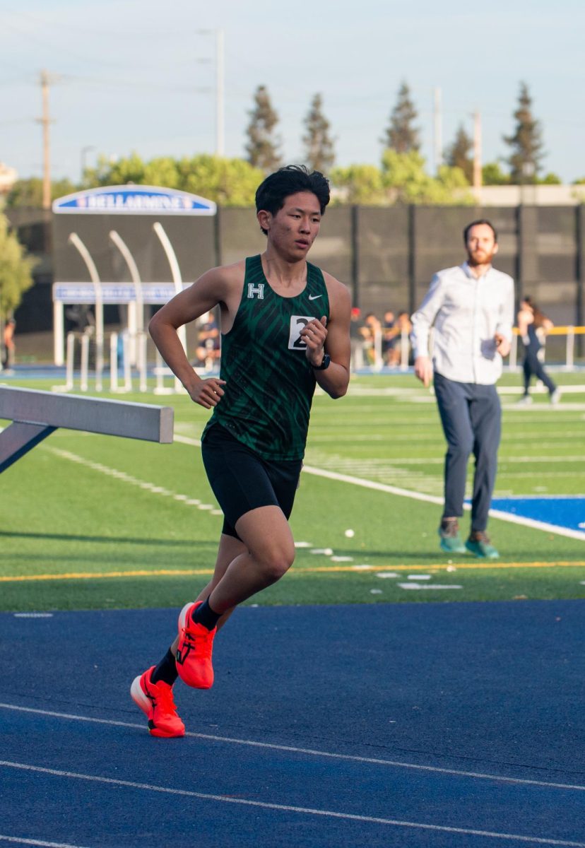 Sophomore Robinson Xiang pumps his arms while running. Robinson finished first and set a new personal record in both the 1600-meter and 3200-meter dash during the meet. 