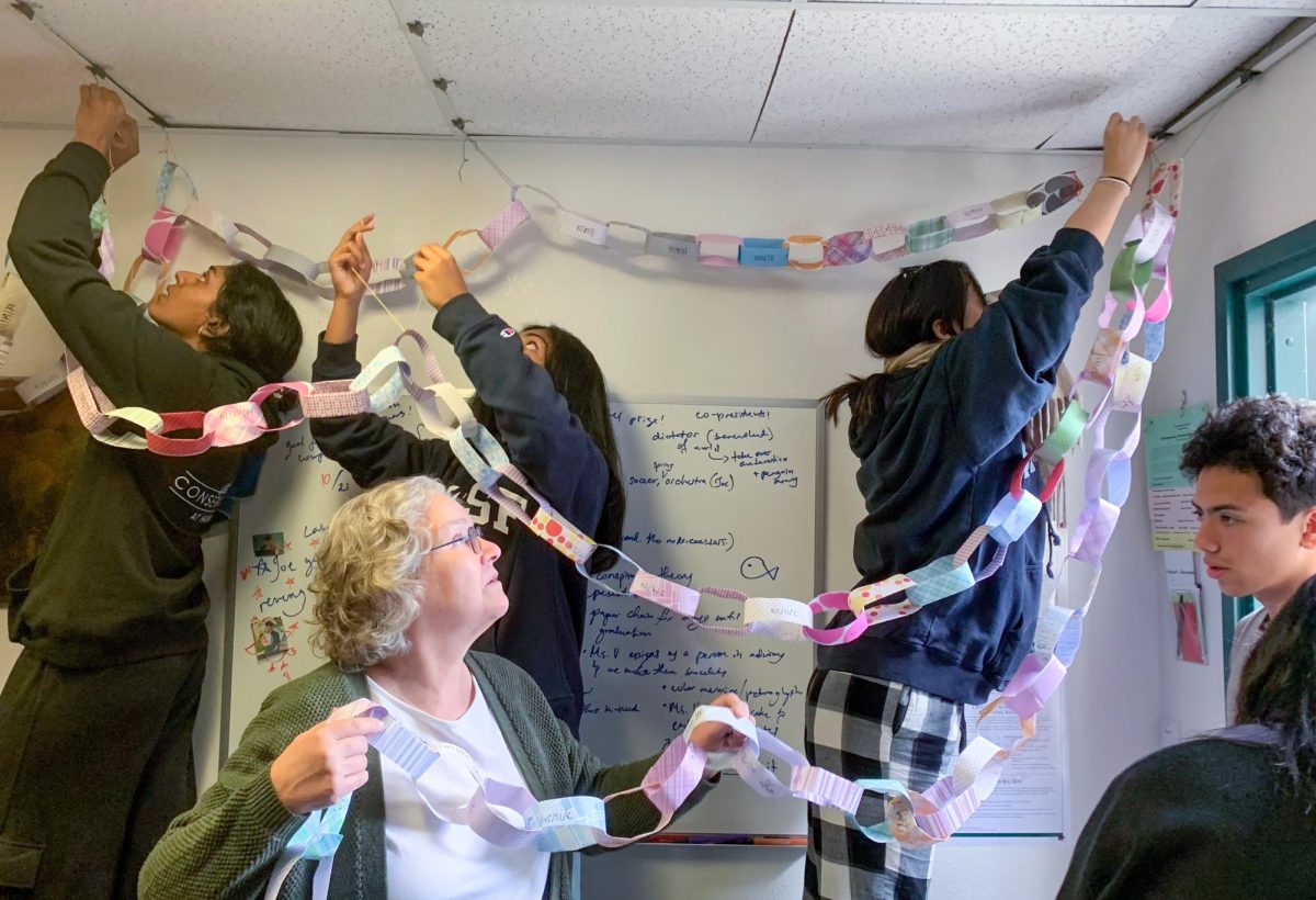 Seniors in Library Director Lauri Vaughan’s advisory group string up a paper chain in her office. Each link on the chain represented one day before their graduation date.