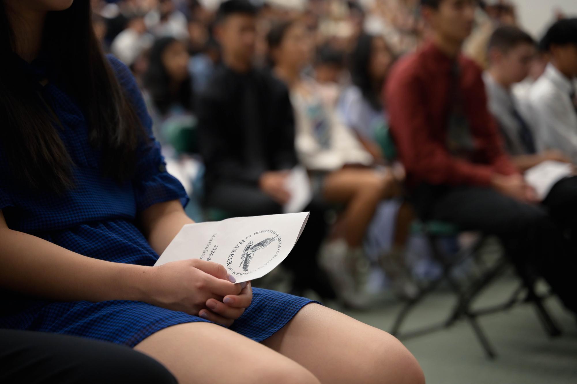 A frosh holds the Matriculation program during speeches. The school read the Matriculation Oath together, with frosh facing upperclassmen and staff. 