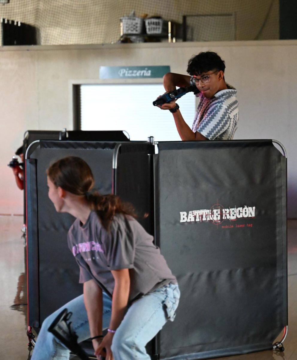 Rushil Jaiswal takes aim at fellow senior Claire Anderson during laser tag. Players were split into red and blue teams.