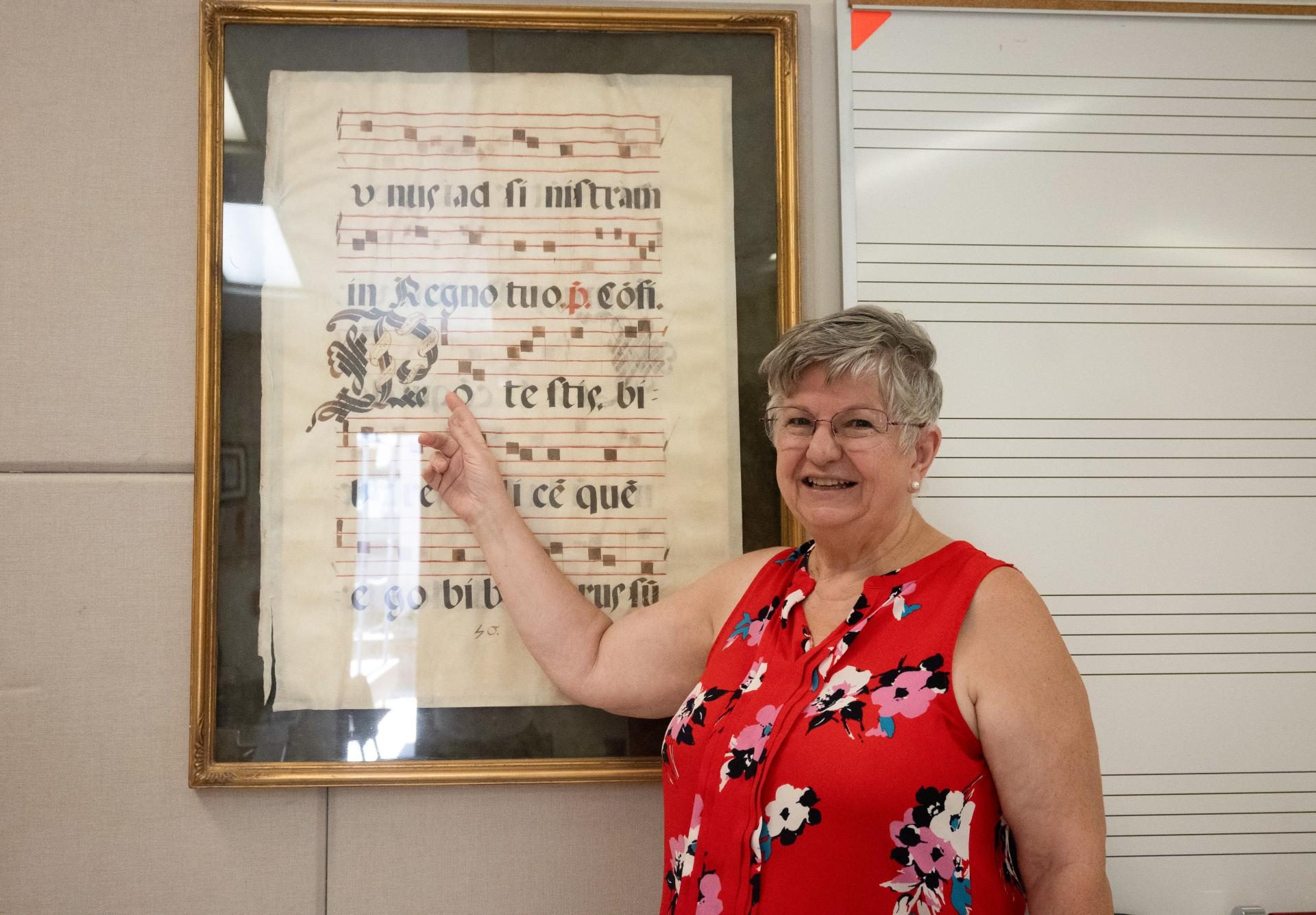 Susan Nace points at the sheet music notation for a Gregorian chant framed in her room, which dates back to 1553. This piece of musical history once served as a guide for choristers singing in a Roman Catholic church.