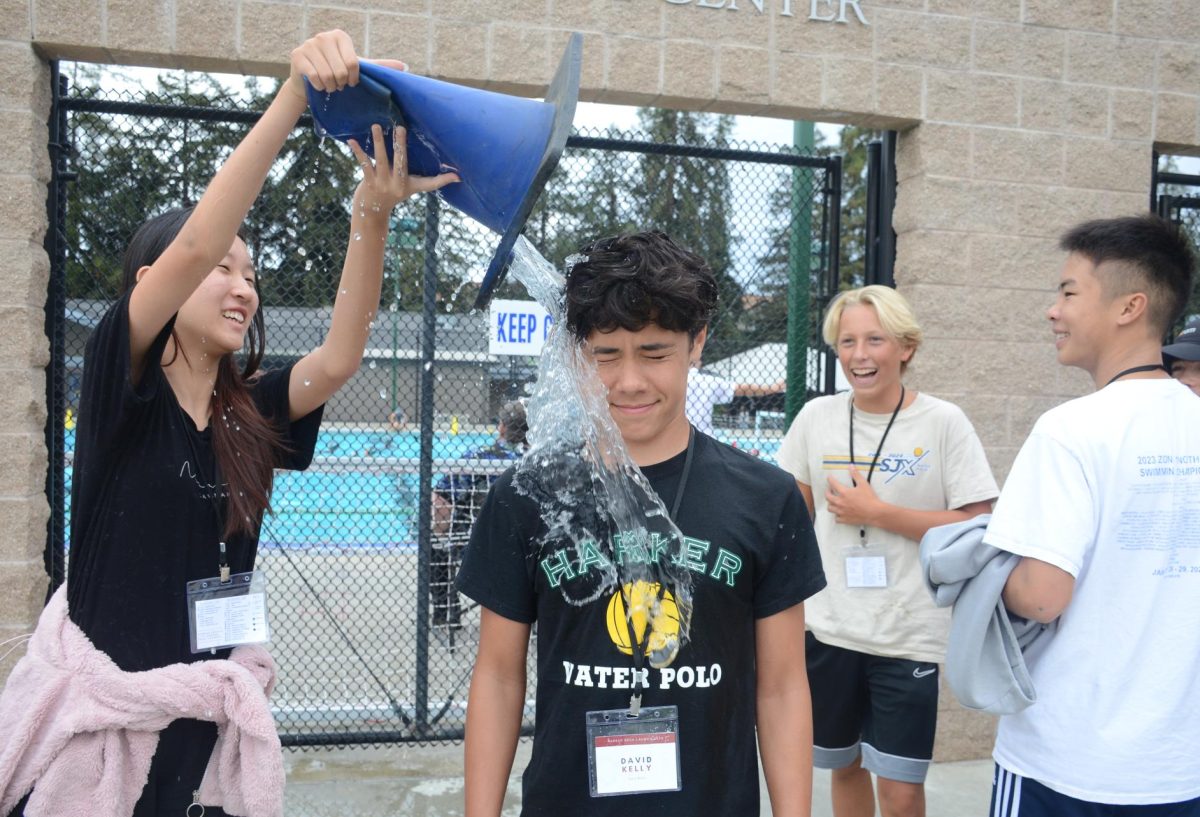 Abella Cai (9) pours a cone of water onto Director of Logistics David Kelly (10) during the scavenger hunt. Other team-building activities included races, portrait drawing and solving puzzles given by officers.