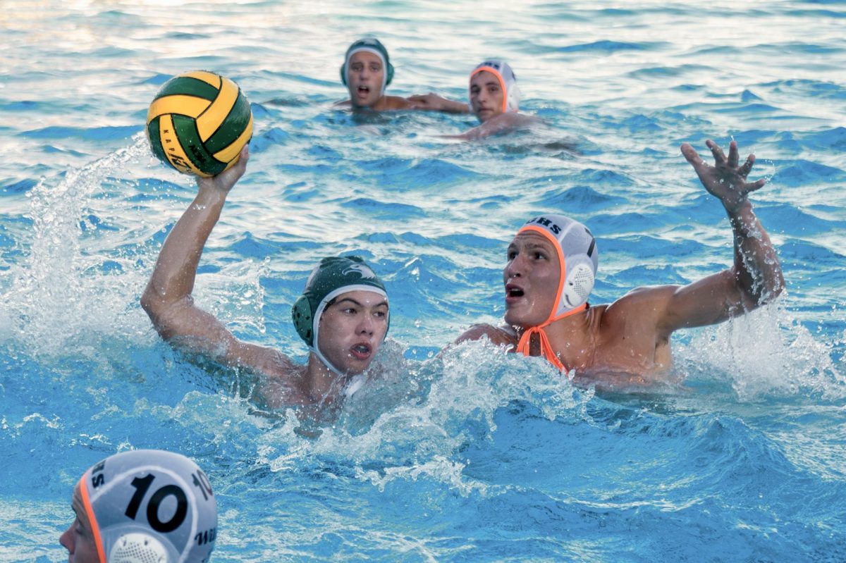 Oskar Baumgarte (12) prepares to shoot the ball over a sea of defenders. Varsity boys water polo ultimately lost to Los Gatos High School 8-14.