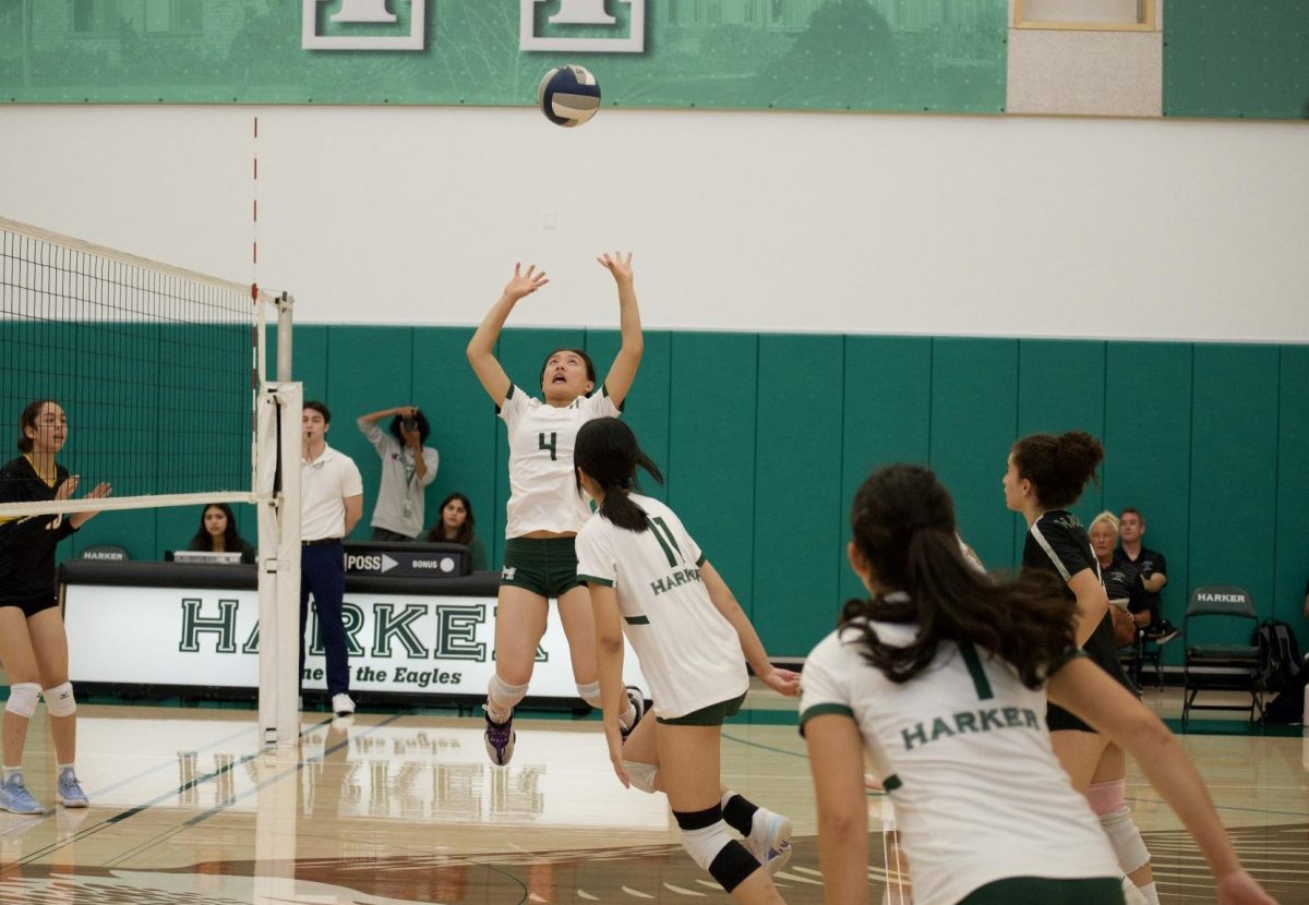 Setter Keira Chang (11) jumps and raises her arms to set the ball for her teammate during the varsity girls volleyball game on Sept. 17. The Eagles trailed at the start of each set but ultimately defeated Pinewood High School.