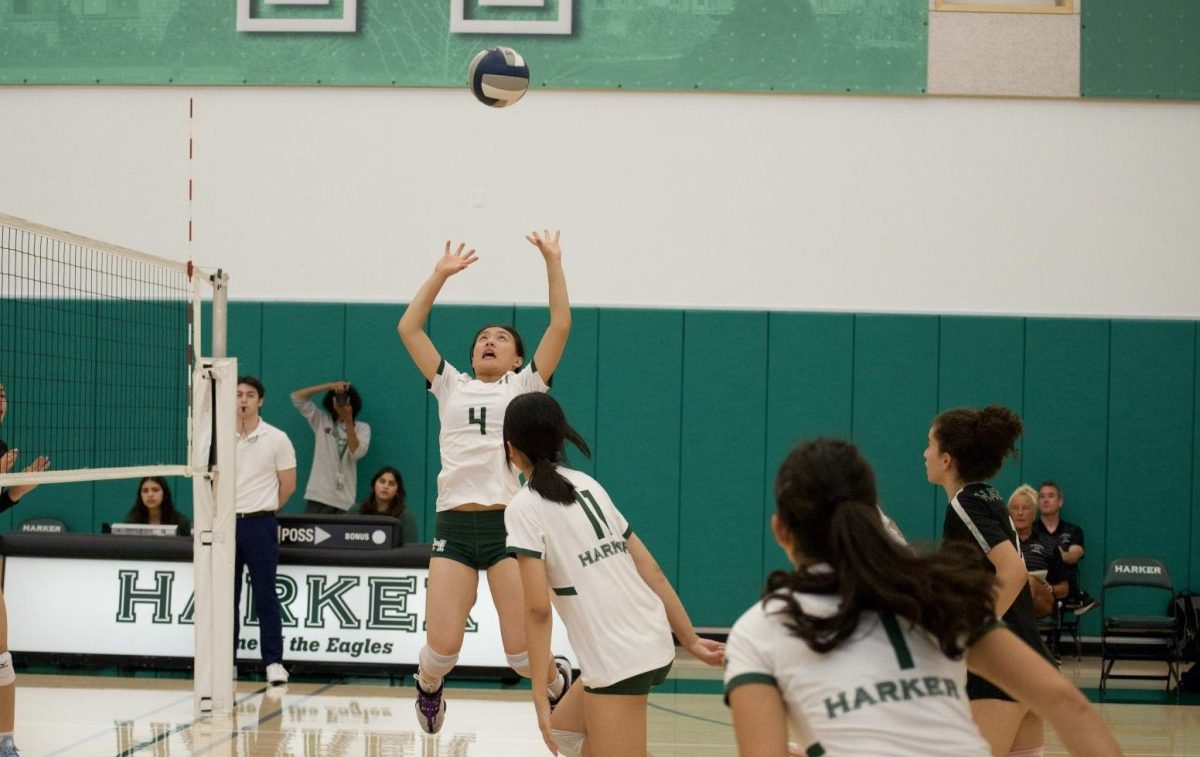 Setter Keira Chang (11) jumps and raises her arms to set the ball for her teammate during the varsity girls volleyball game on Sept. 17. The Eagles trailed at the start of each set but ultimately defeated Pinewood High School.