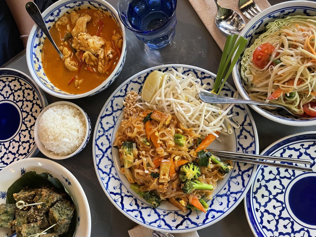 Intricately patterened dishware presents a vibrant spread of pad thai, panaeng curry, garlic chive cakes and green papaya salad. Pineapple Thai created an immersive cultural experience with their attention to detail in both the taste and appearance of each of its dishes.