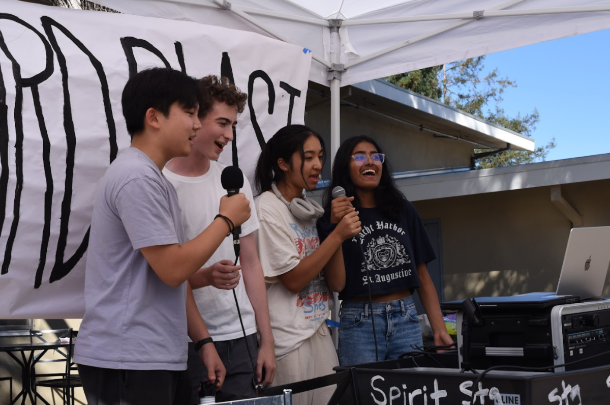 Seniors Aaron Bao, Robert Fields, Rumi Gupta and Kashish Priyam sing at the karaoke booth. Spirit Night also allowed the classes to finish painting their eagles.