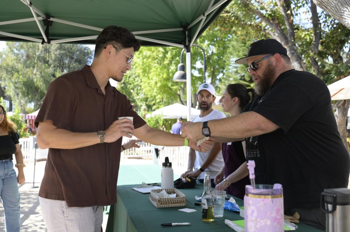 Middle school English teacher Mark Gelineau ('90) checks in an attendee. Gelineau enjoys this role because it allows him to connect alumni with other classmates or former friends also attending the Barbeque.