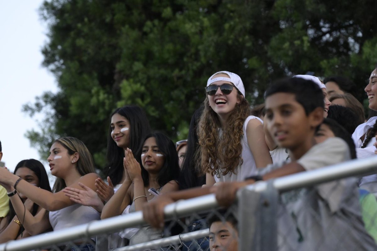 Senior Sara Glusman cheers on the Eagles from the student section. This year's homecoming theme is "Blizzard Blast," and fans decked out in white clothing and face paint to support the Eagles.