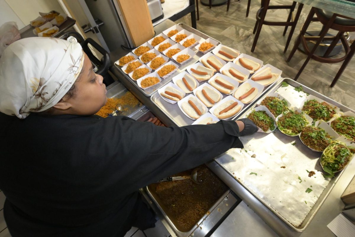 Culinary intern Alaiza Albizu sets out food at the Veggie Cafe before lunch begins. In addition to vegetarian and vegan options, Manzanita Hall offers a bevy of desserts, cold cuts and fruits. 