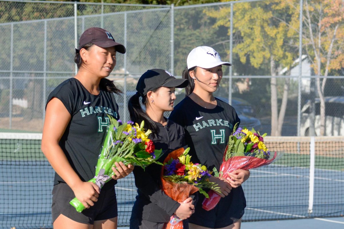 Seniors Audrey Feng, Charlize Wang and Olivia Guo hold bouquets and smile for a picture during their varsity girls tennis senior night on Oct. 22. The team went on to crush Sacred Heart Preparatory 6-1. 