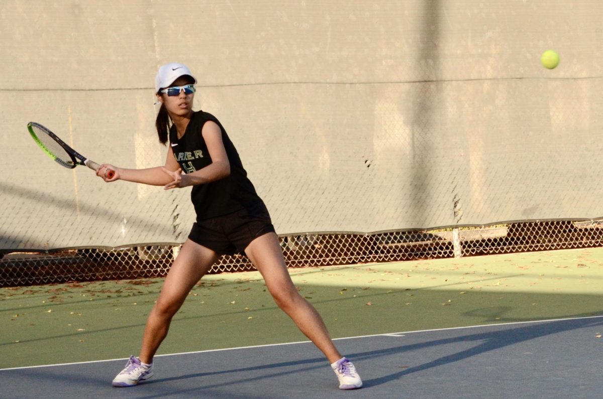 Sophomore Claire Xu prepares to hit the tennis ball with a forehand swing. Claire defeated her opponent in a single 8-3 set. 