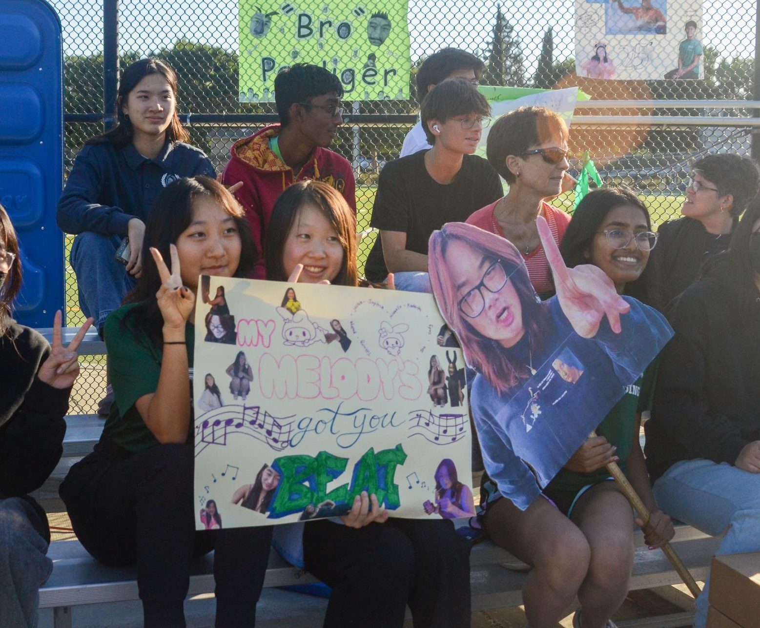 Seniors Sophia Liu, Iris Cai and Kashish Priyam hold up posters to support Melody.  “It was exciting, and we were all very proud watching her," Iris said. 