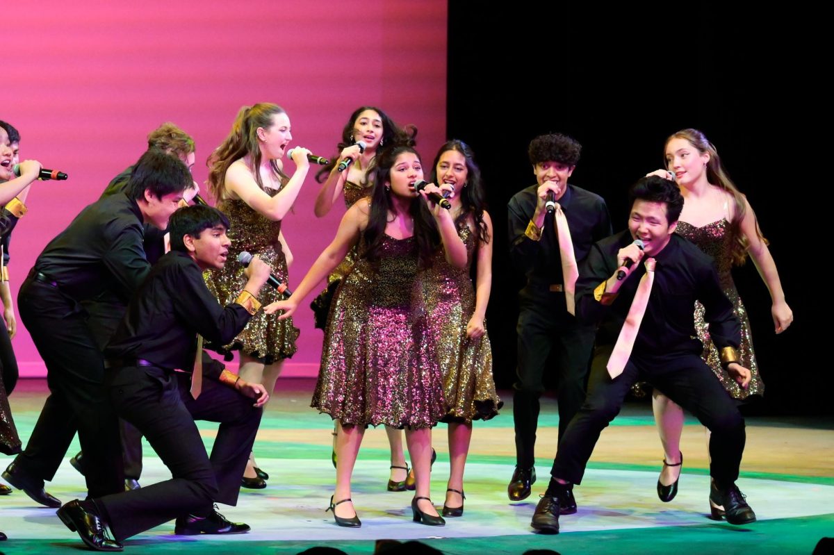 Downbeat surrounds senior Saanvi Bhargava during her solo. Other singing acts included the middle school Concert Choir and the lower school Harmonics.