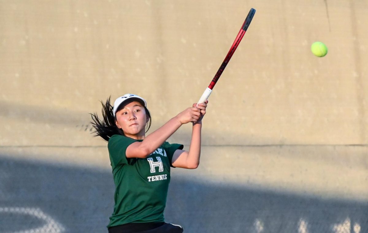 Olivia Guo (12) hits the ball during her match against Menlo's Emily Li. She started off strong, winning 7-6 in her first set, but went on to lose 2-6 and 3-10 in a hard-fought game.