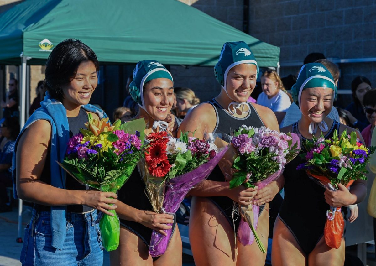 Seniors Abby Lim, Keren Eisenberg, Summer Adler and Melody Yin hold bouquets and pose for a photo during their senior night ceremony. Varsity girls water polo defeated Mountain View High School 12-5 on senior night. 