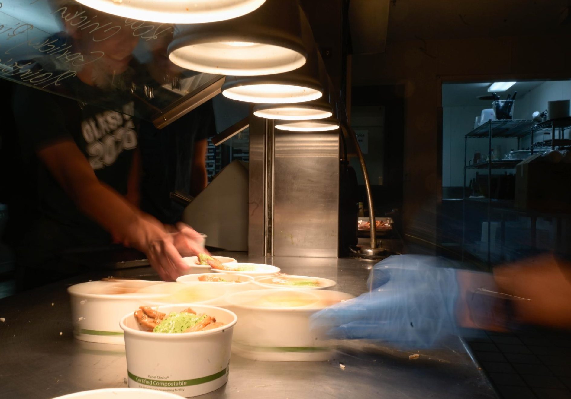 Chef Gustavo Parra hands off food at Chef's Grill to awaiting students. This Manzanita Hall station is one of the most popular. 