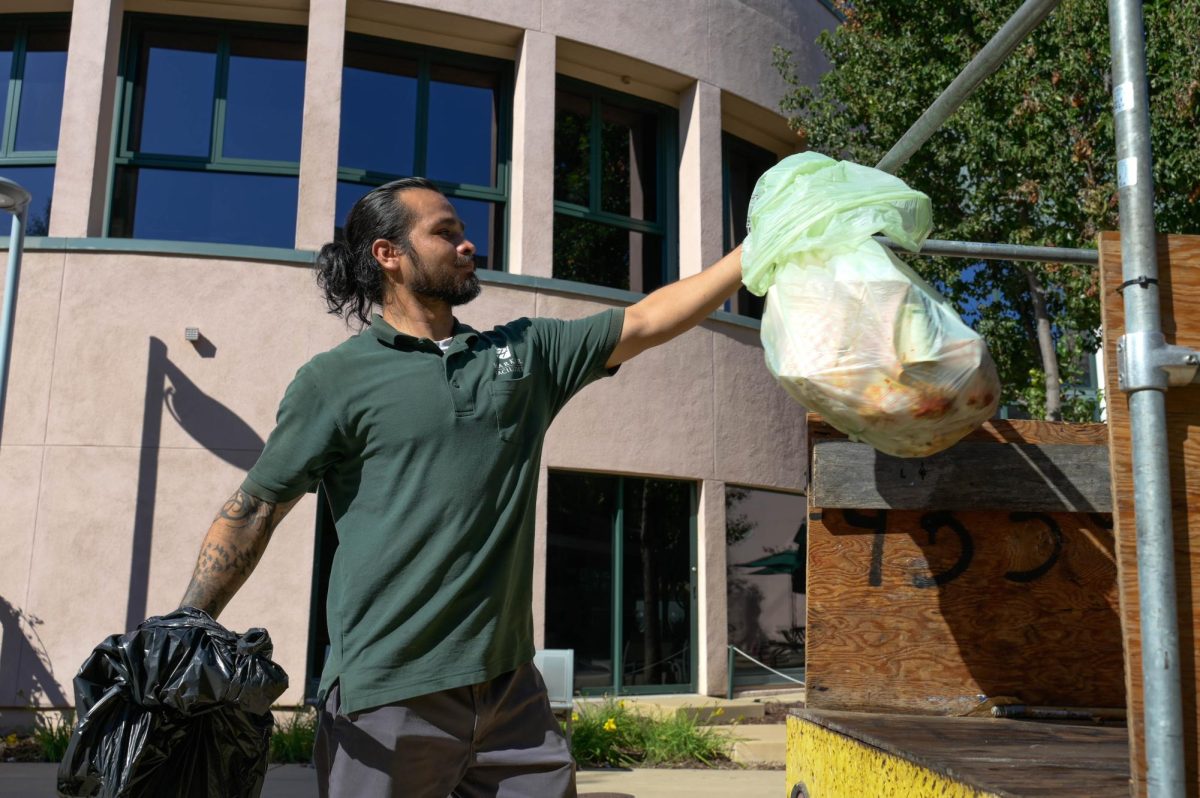 Grounds Crew member Elidio Espinoza carries a bag of trash and prepares to load it into his vehicle. He typically starts emptying trash cans from Shah, which is farthest away from the dumpsters, and makes his way toward the Nichols and Dobbins area.