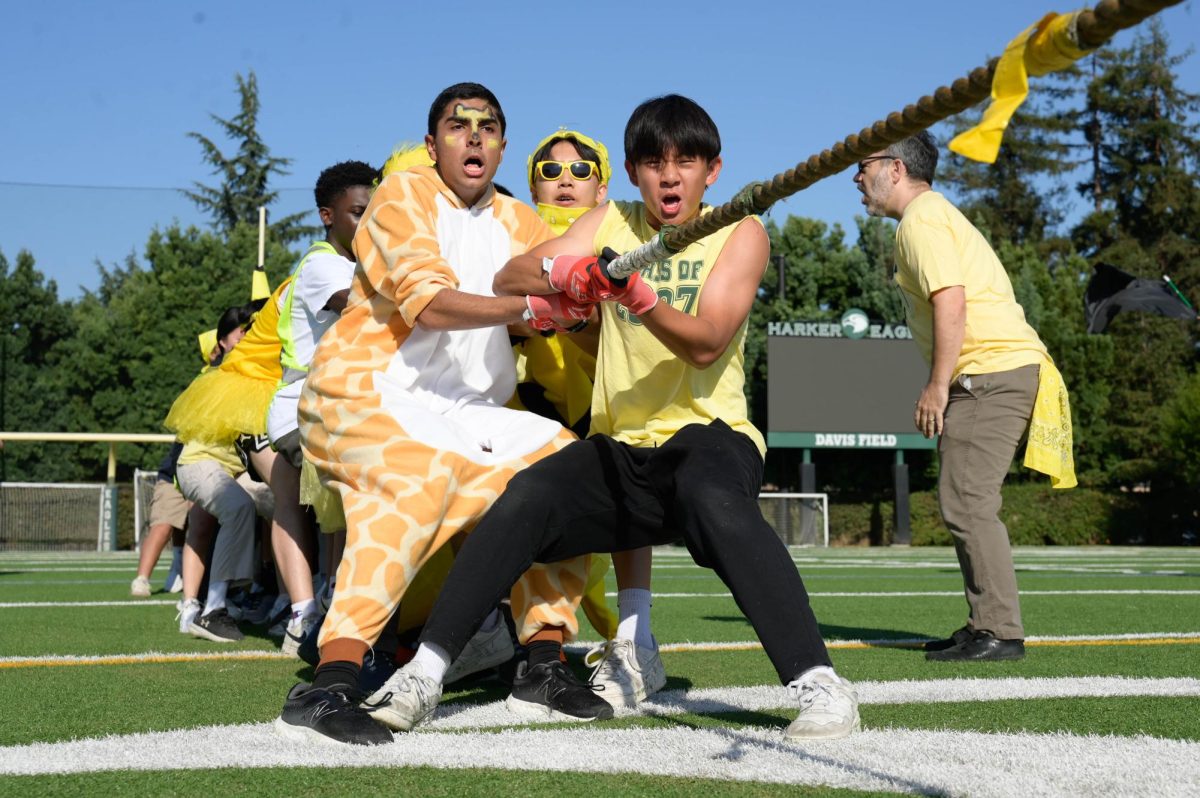 Sophmores Ryan Miao, Yash Belani and Brandon Labio attempt to stop sliding forwards during their match against the seniors. In a pre-match huddle, they practiced their pulling tempo.