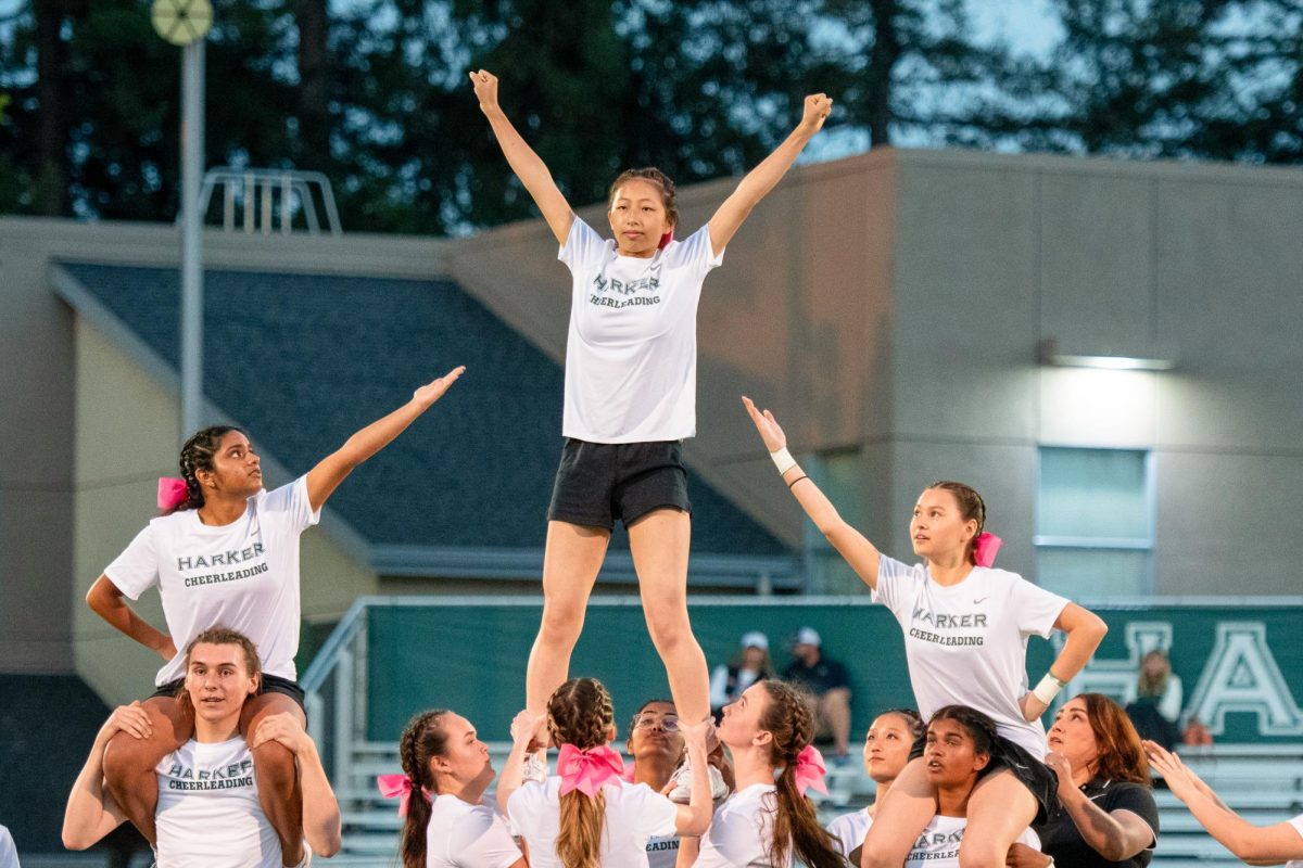 Christy stands at the top of a lift during a cheer routine at a varsity football game. On top of figure skating, Christy must juggle two sports with her academic work load.