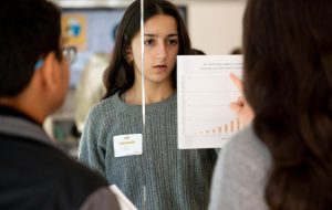 Student Diversity Coalition representative Elie Ahluwalia (11) analyzes a bar graph during the media literacy workshop. The graphs contained some of the clues necessary to solve an escape room-style puzzle.