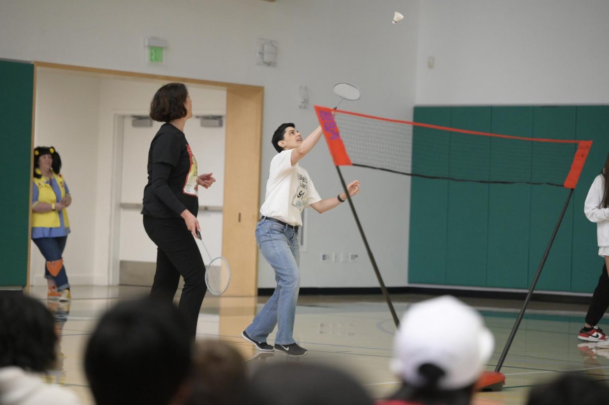 Physics teacher Lisa Radice reaches up to hit the shuttlecock during LIFE Board's badminton tournament. In the third place match, Radice, upper school assistant division head Kelly Horan and math teacher Bradley Stoll faced off against frosh Adrian Jia and Daniel Xi.