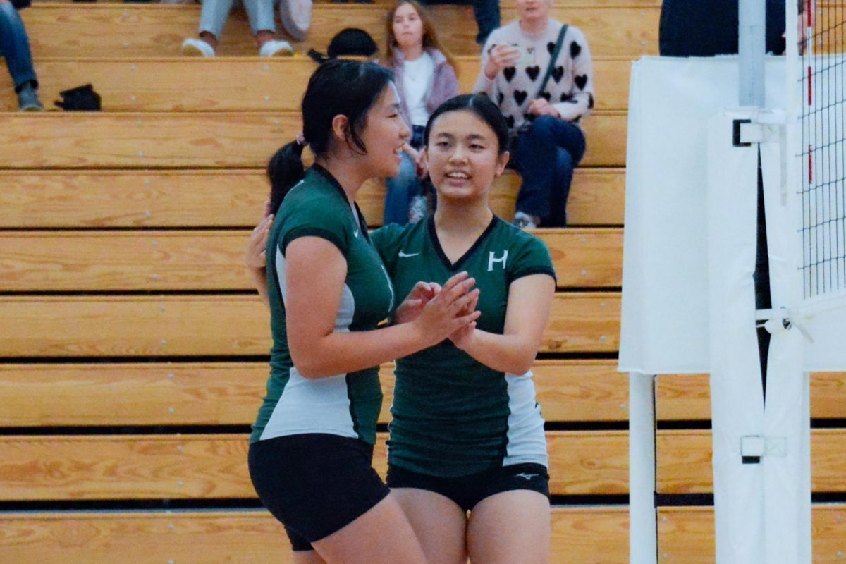 Outside hitter Sophie Wu (9) congratulates middle blocker Sarah Wang (10) after she scores a kill in the first set. The Eagles won the first set 25-19 against Priory.