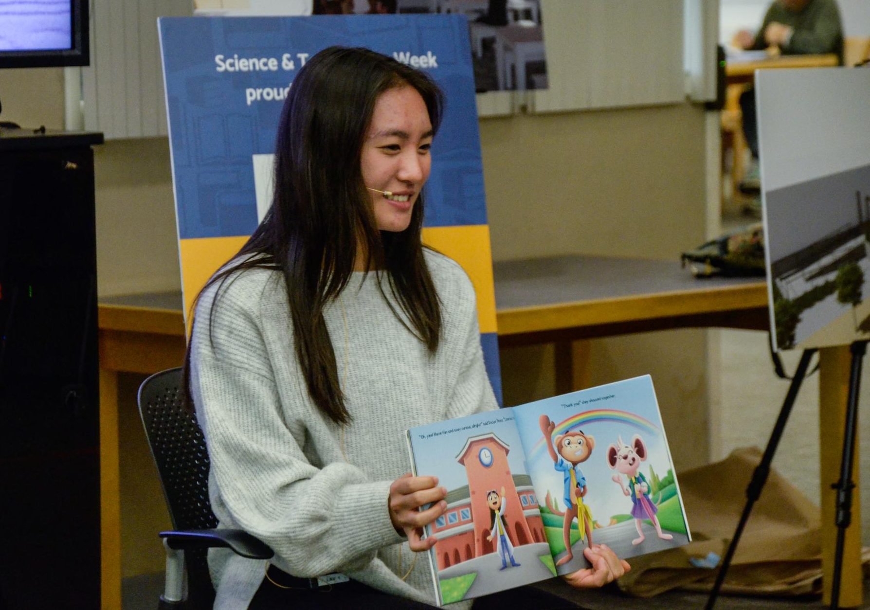 Junior Keira Chang smiles as she reads her children's book "Marinara and Alfredo: How Do Rainbows Work?" to preschoolers. Taking part in Los Altos Library's Science and Technology Week event, this was her first time reading her book at a library rather than a school classroom.