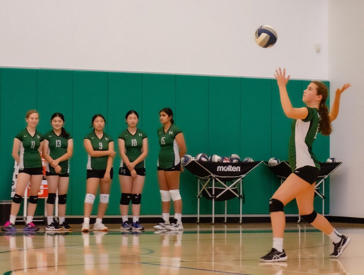 Outside hitter Maya Horan (9) tosses the volleyball in preparation to serve during the frosh girls volleyball team's game against Priory. The team dominated in two sets 25-19 and 25-5. 