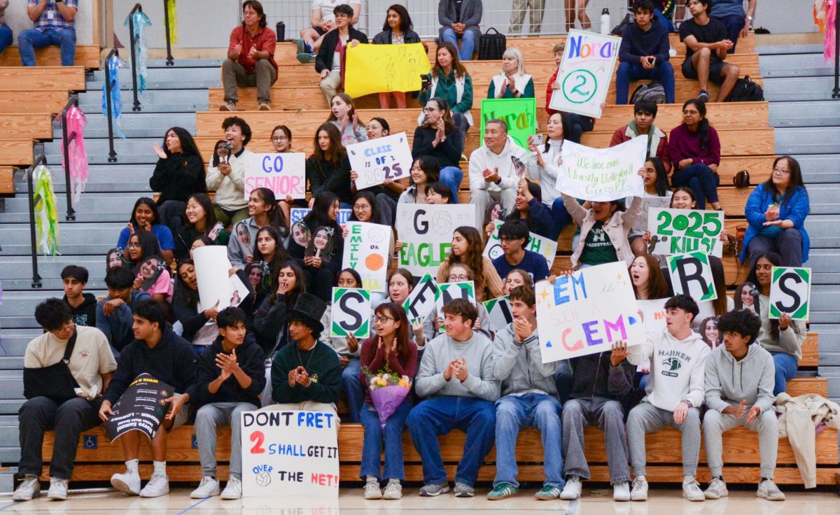 Students, parents and teachers cheer for the seniors during the ceremony. They created posters and face cutouts in support of the seniors, supporting the team with their energy.