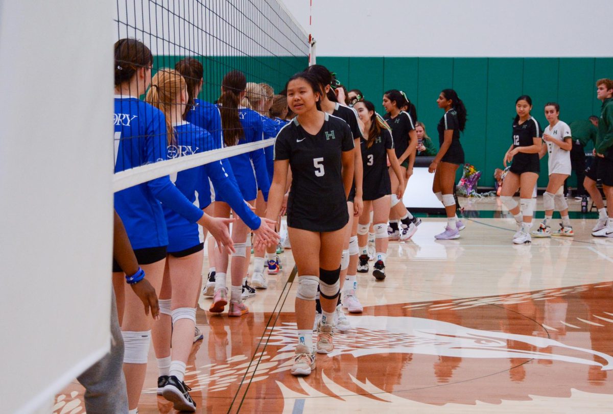 Setter Brooke Kubose (11) leads the team to high five Priory players after the senior night ceremony. The varsity girls volleyball team celebrated their four seniors with speeches and gifts. 