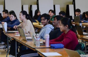 Vishwa Vijay (10), Aarush Vailaya (12) and Claire Tian (10) laugh at a joke before the exam begins. 150 students convened at the Auxiliary Gym before 8 a.m. that morning to take the exam.