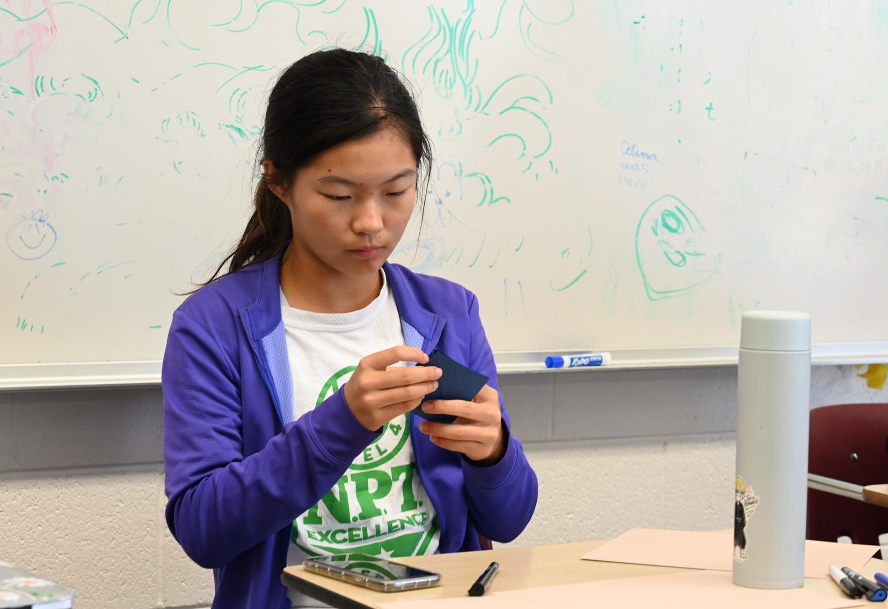 Frosh Kendra Zhao folds a paper origami during Key Club and Origami Club's meeting on Tuesday. Students made a collective of 50 cards and origami animals. 