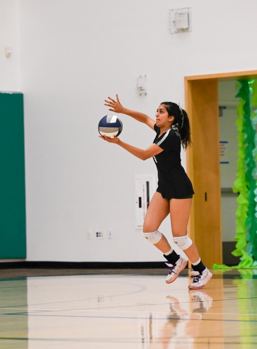 Navya Samuel (12) prepares to serve the ball during the second set. Navya joined the varsity volleyball team as a frosh and played for four seasons. 