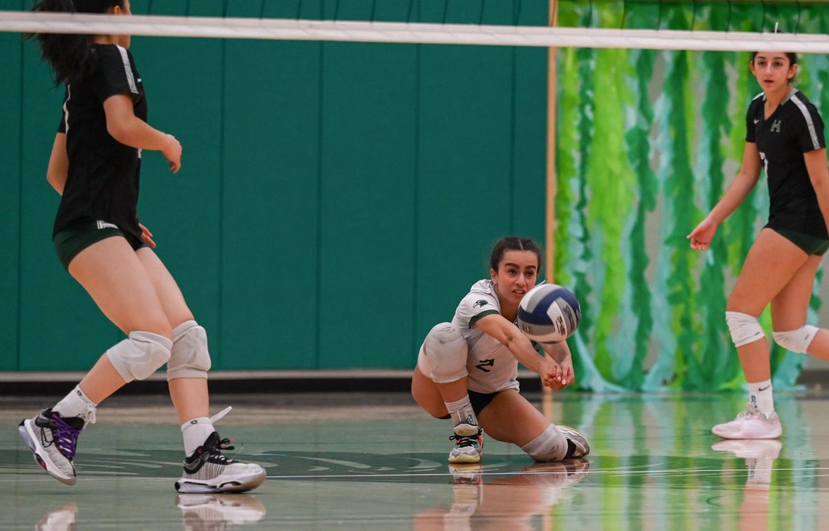 Norah Mehanna (12) dives for the ball during the game. The varsity girls volleyball team dominated Priory 25-16, 25-19, 25-10 during their senior night game. 