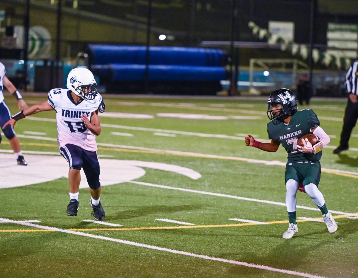 Quarterback Rayan Arya clutches the football as he confronts a Warriors defender. Rayan has played as quarterback on the varsity football team for the past four years. 